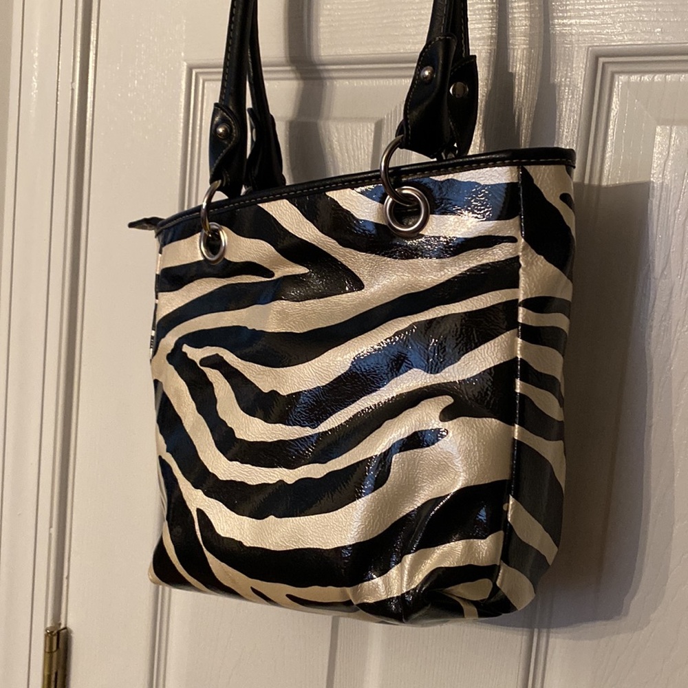 Strada handbag with black and cream zebra print. Two zippered pockets on front.